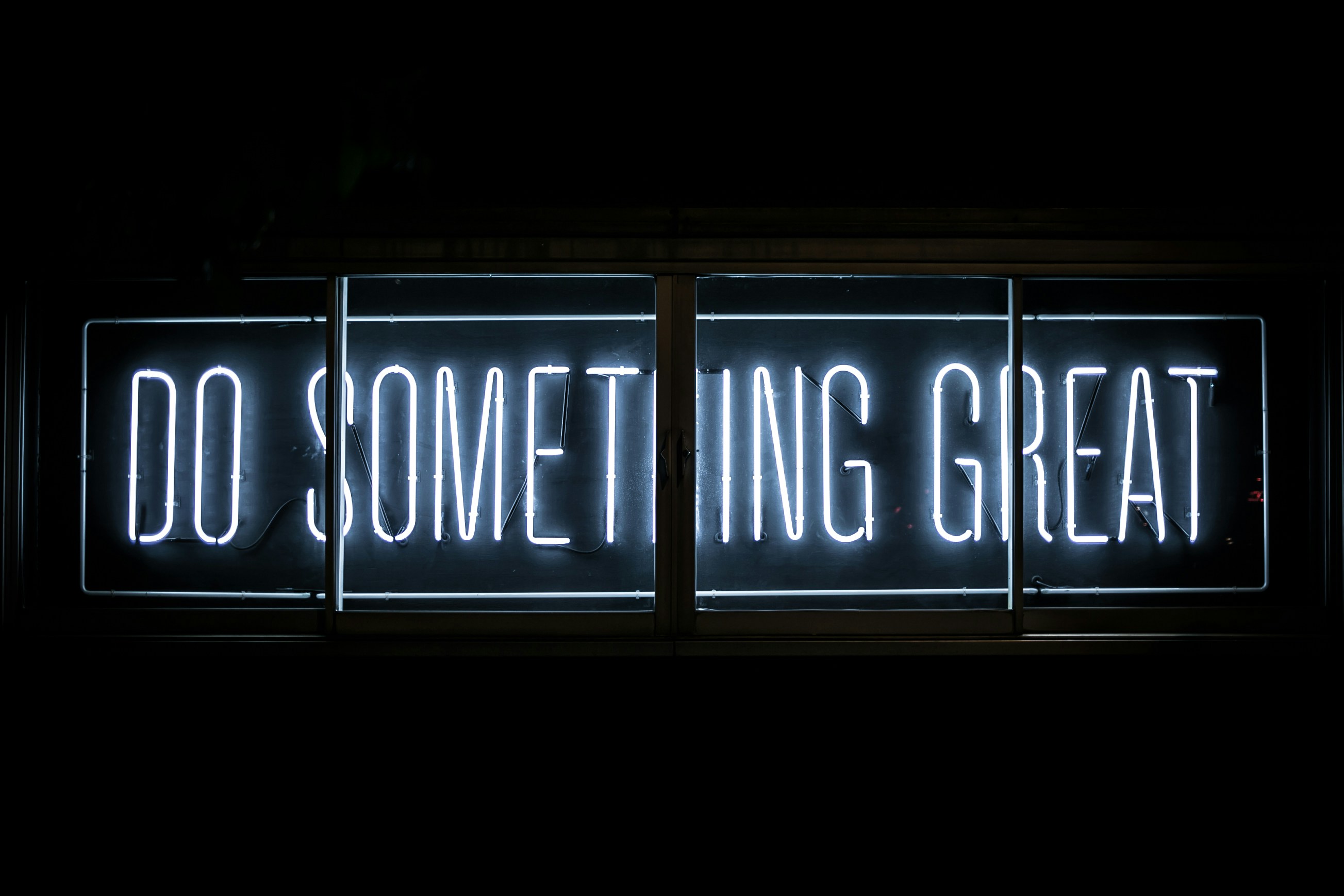 Neon sign reading 'Do something great', symbolizing ethical reflection